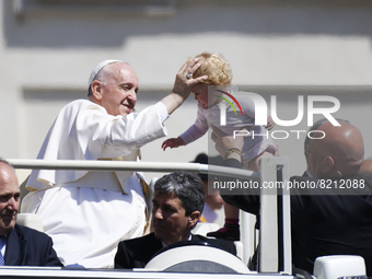 Pope Francis greets children as he arrives in St. Peter's Square on the occasion of his weekly general audience at the Vatican, Wednesday, M...