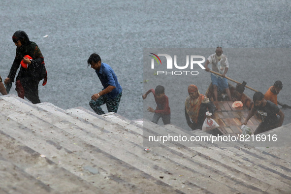 Passengers cross the river Buriganga by boat during rain in Dhaka, Bangladesh on May 12, 2022. 