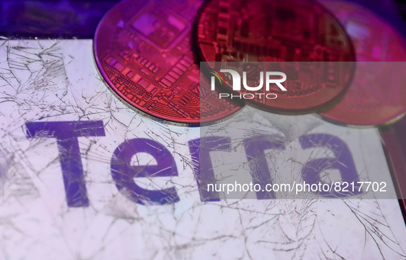 Terra logo displayed on a phone screen is seen through a broken glass with representation of cryptocurrency in this illustration photo taken...