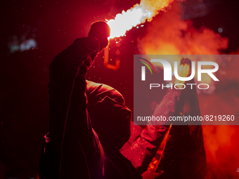 A hooded person holds a flare, in Santiago, Chile, on May 13, 2022 during a demonstration for the death of Journalist Francisca Sandoval, wh...