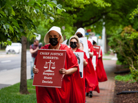 Demonstrators in handmaids constumes from The Handmaid's Tale en route to protest against the Supreme Court's preliminary decision to overtu...