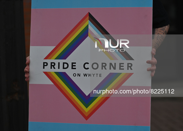 An activist holds a placard with a sign 'Pride Corner On Whyte'.More than 100 local LGBTQ2S + supporters gathered Friday evening at the sou...