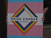 An activist holds a placard with a sign 'Pride Corner On Whyte'.More than 100 local LGBTQ2S + supporters gathered Friday evening at the sou...
