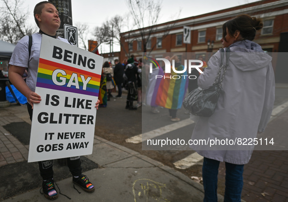 An activist holds a poster with words 'Being Gay Is Like Glitter. It Never Goes Away'.More than 100 local LGBTQ2S + supporters gathered Fri...