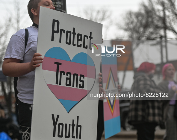 An activist holds a placard with words 'Protect Trans Youth'.More than 100 local LGBTQ2S + supporters gathered Friday evening at the southe...