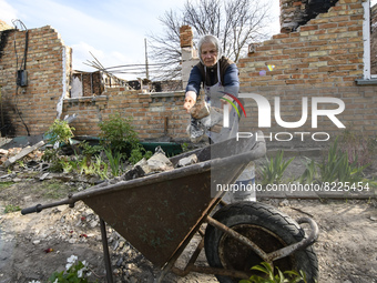 Local resident cleans the remains her house destroyed during the Russian occupation of Zahaltsi village near Kyiv, Ukraine, ​May 13, 2022. (