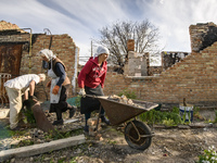 Local residents clean the remains their house destroyed during the Russian occupation of Zahaltsi village near Kyiv, Ukraine, ​May 13, 2022....