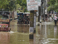 Commuters make their way on a waterlogged street after a heavy rainfall in Guwahati, Assam, India on 14 May 2022.  (
