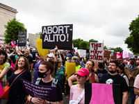 Thousands of people march down Constitution Avenue toward the Supreme Court during the flagship event of a nationwide day of protest for rep...