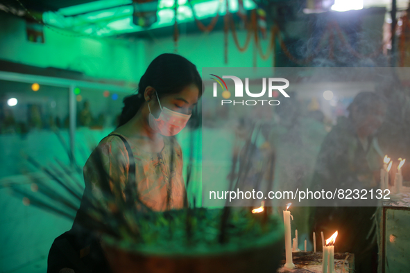 A Buddhist devotee lights candles at a temple during the Buddha Purnima festival in Dhaka, Bangladesh on May 15, 2022. 