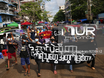 Young demonstrators hold a banner as they march during an anti-coup protest in Yangon, Myanmar on May 16, 2022.
 (