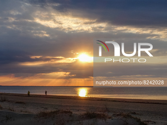 People walking at the beach during a sunset are seen in Jurmala , Latvia on 5 May 2022 Jurmala is a resort town about 25 km west of Riga, sa...
