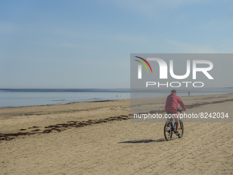 A man cycling at the beach is seen in Jurmala , Latvia on 5 May 2022 Jurmala is a resort town about 25 km west of Riga, sandwiched between t...