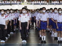 Students wear facemasks, as they attend a flag-raising ceremony before the start of classes at Assumption College in Bangkok, Thailand, 17 M...