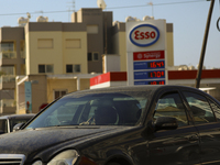 A driver is talking on the phone as he passes a gas station at the Mediterranean port of Limassol. Cyprus, Tuesday, May 17, 2022. As the war...