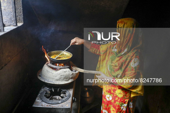 A woman seen using an earthen stove as around 100,000 gas line has been disconnected over a week in Kamrangirchar at Dhaka, Bangladesh om Ma...