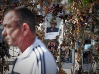 People walk past a wall of flowers with pictures of Ukrainian victims of the Russian invasion in Warsaw, Poland on 17 May, 2022. The conflic...