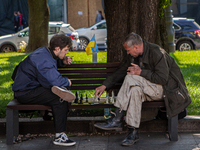 Two men play chess on a park bench in Lviv next to a Ukrainian flag on May 18, 2022. According to the United Nations, 1.8 million people hav...