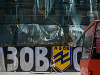 A woman walks by street art depicting the Azov Battalion symbol in Lviv on May 18, 2022. A controversial unit of the Ukrainian National Guar...