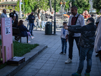 A boy aims a BB gun at a picture of Russian president Valdimir Putin in Lviv on May 19, 2022. According to the Ukrainian Prosecutor General'...