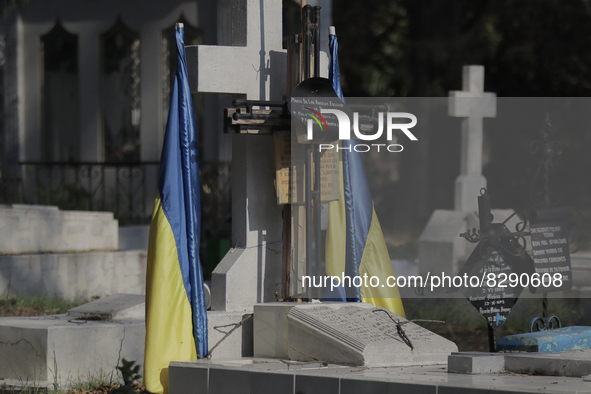 Two Ukrainian flags hang over a cross and tombstone inside the Dolores Cemetery in Mexico City, prior to the burial ceremony and posthumous...