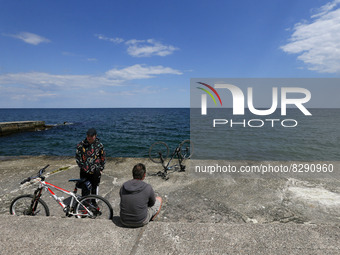 People rest the embankment of the Black sea in Odesa, Ukraine on 24 May 2022. The beach season in Odesa is usually considered open at the en...