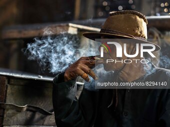 SLEMAN, YOGYAKARTA, INDONESIA - MAY 20: Supardi Seswowarsito, 71, smokes as traditional Javanese Keris daggers are made at a workshop on May...