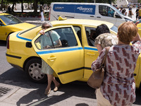 A woman gets out of a taxi near Syntagma square in the center of Athens, Greece on May 25, 2022. (