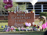 Officers helped bring items from loved ones to the Robb Elementary School sign in Uvalde, Texas, May 25, 2022.  (