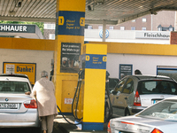a woman pumps gasoline into his car at an Jet gas station in Cologne, Germany on June 1, 2022 as Germany starts cutting taxes on Petrol and...