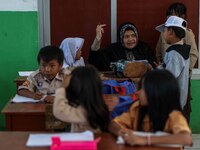 A teacher is seen teaching students at a school in Tugu Utara Village, Regency Bogor, West Java province, Indonesia on 2 June, 2022. (