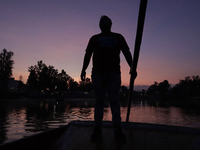 Backlighting of a paddler during sunrise on Lake Los Reyes in Tláhuac, Mexico City, where several people gathered to participate in a boat r...