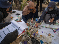 Environmental activists sort out samples of plastic waste in Palu Bay Beach, Central Sulawesi Province, Indonesia on June 5, 2022. The sampl...