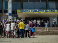 People wait in the entrance of the Culture Palace of Kostiantynivka to receive humanitarian aid. The supply of some goods was reduced drasti...