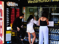People exchange money at an exchange office in Istanbul on June 7, 2022. President Tayyip Erdogan's statements that the interest rate cut wi...
