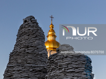 Towels of sand bags which cover Princess Olga large monument at Michailovskyi Square are seen in front of Saint Michail Monastery in an Old...