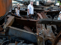 A family attends an exhibition of destroyed Russian war vehicles exhibited at Michailovskyi Square in an Old Town of Kyiv, Ukraine on June 8...