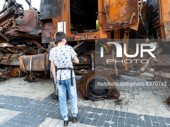 A boy attends an exhibition of destroyed Russian war vehicles exhibited at Michailovskyi Square in an Old Town of Kyiv, Ukraine on June 8, 2...
