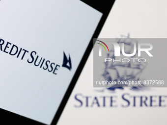 Credit Suisse logo displayed on a phone screen and State Street logo displayed on a screen are seen in this illustration photo taken in Krak...