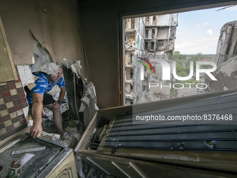 Local resident collects unbroken items at his apartment inside a residential building destroyed by russian army airstrike in the Borodianka...