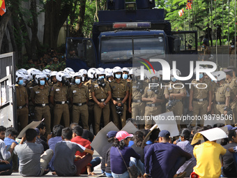 Sri Lankan undergraduate students sit on the road after being attacked with tear gas by police officers in front of Ministry of Education du...