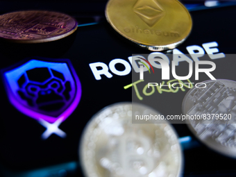 RoboApe Token logo displayed on a phone screen and representation of cryptocurrencies are seen in this illustration photo taken in Krakow, P...
