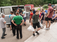 Local volounteers and displaced from the Kherson region are seen during a humanitarian help distribution, in the city center of Hrushivka, U...