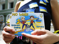 A woman holds a postcard dedicated to the blockade of an yacht of Russian businessman Roman Abramovich by Ukrainian children athletes team i...
