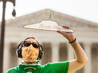 A protester with Rise Up for Abortion Rights holds a coat hanger with the words, 