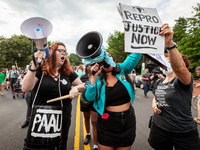 Lauren Handy (left) and Terrissa Bukovinac (center) try to interrupt a pro-choice protest and march against the leaked decision that would o...