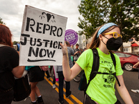 A pro-choice activists carries a sign calling for reproductive justice during a protest against the leaked decision that would overturn Roe...