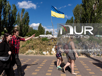 TPeople are seen walking in fron of Ukainian flag in Kiev, Ukraine on June 14, 2022.  As the Russian Federation invaded Ukraine more than 3...