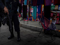 Police officers search a local market in downtown San Salvador during a patrolling operation on April 25, 2022 in San Salvador, El Salvador....