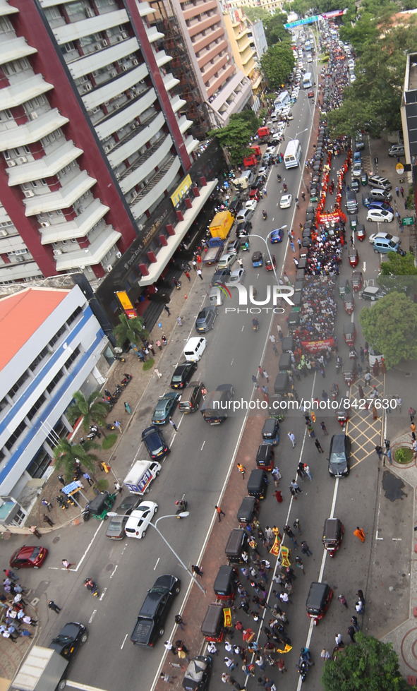 Sri Lankan anti-government protesters march forward demanding the government to step down as hundreds of vehicles are seen lined up waiting...